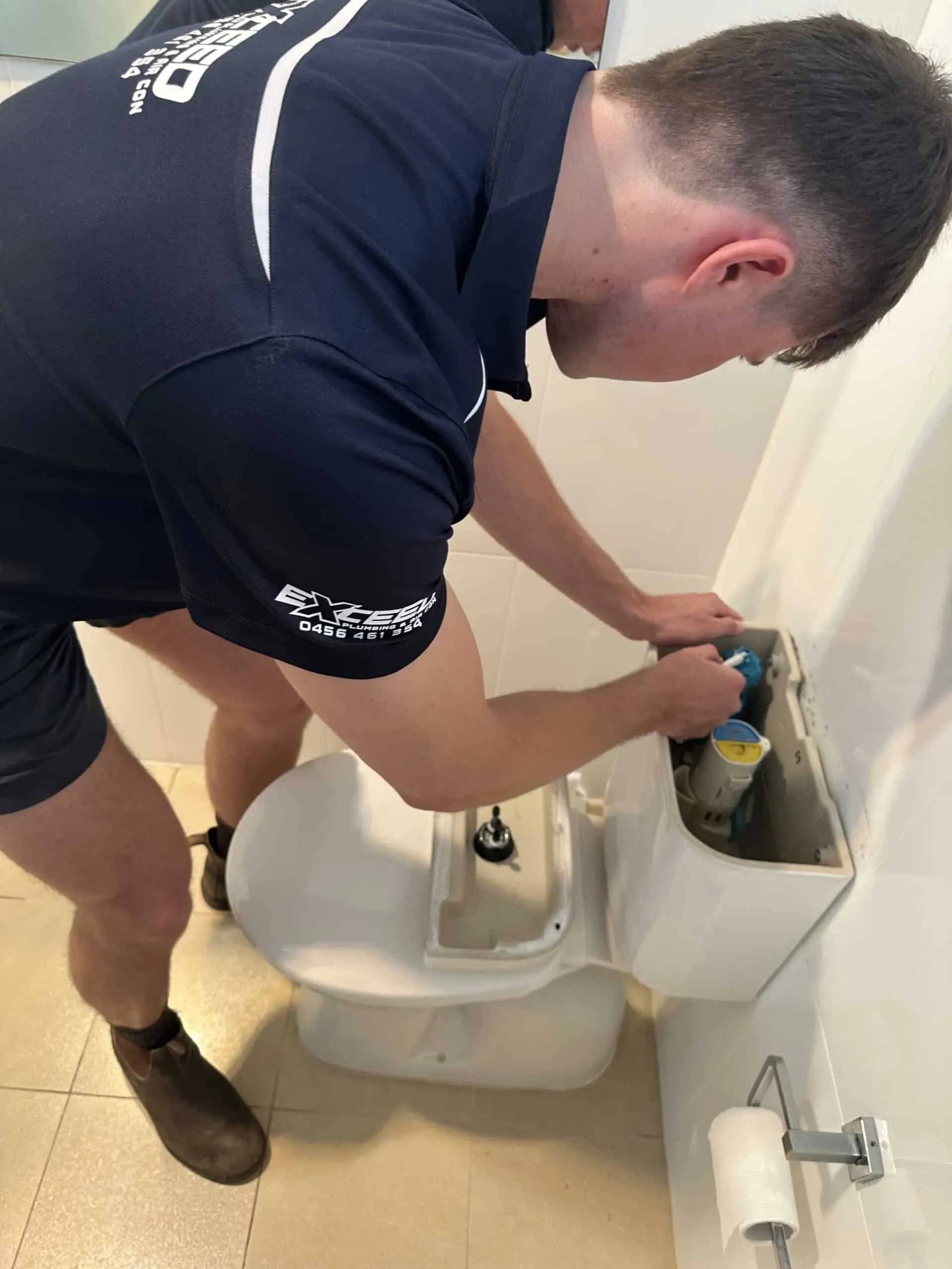 Exceed Plumbing plumber repairing the inside of a toilet cistern