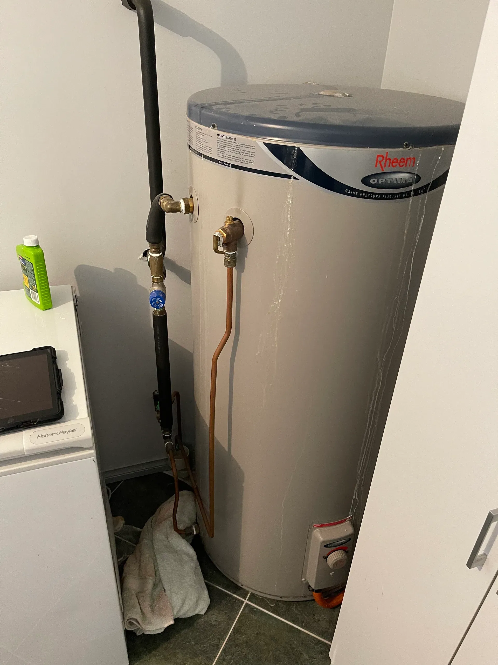 Electric storage hot water system in a laundry