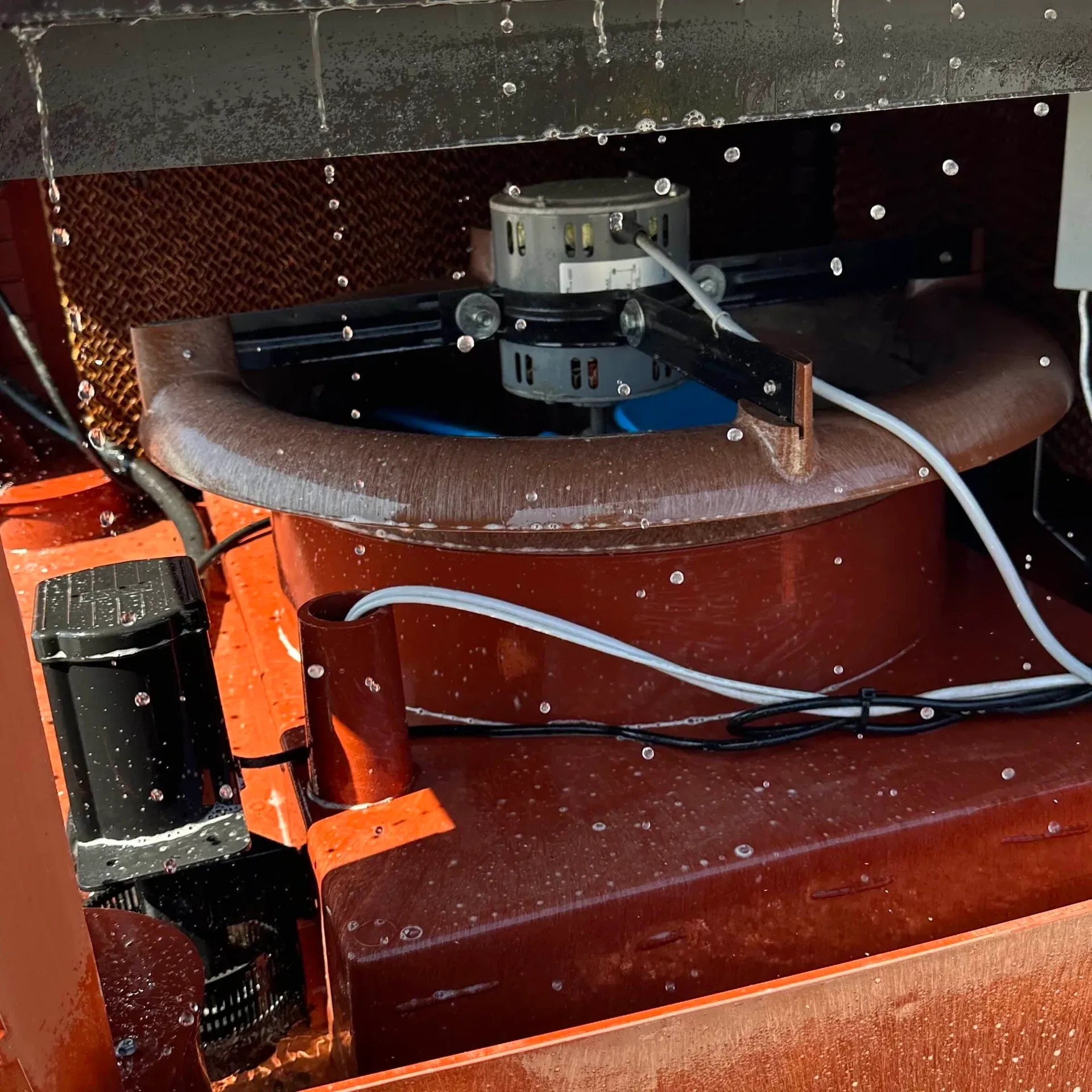 Motor and pads inside a ducted evaporative cooler on an Adelaide roof