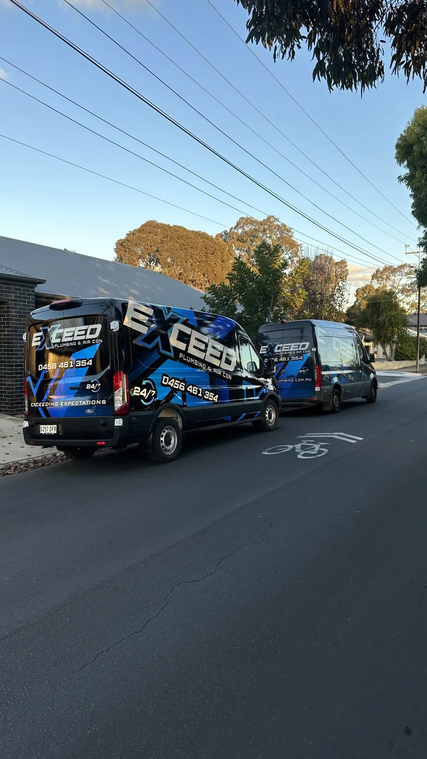Two Exceed Plumbing service vans parked on an Adelaide street