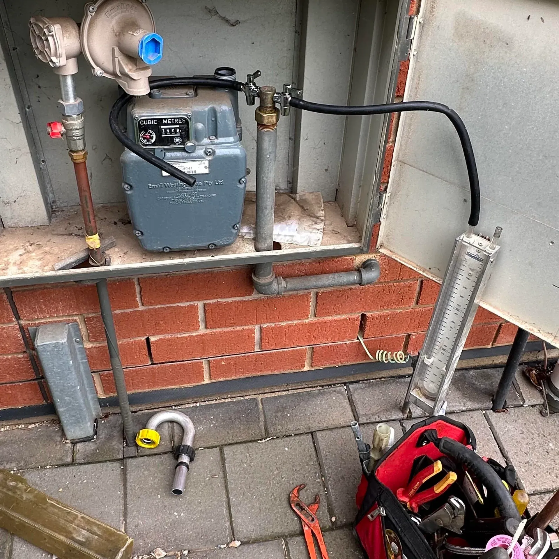 Gas meter and regulator in a meter box, with the gas fitter’s tool bag
