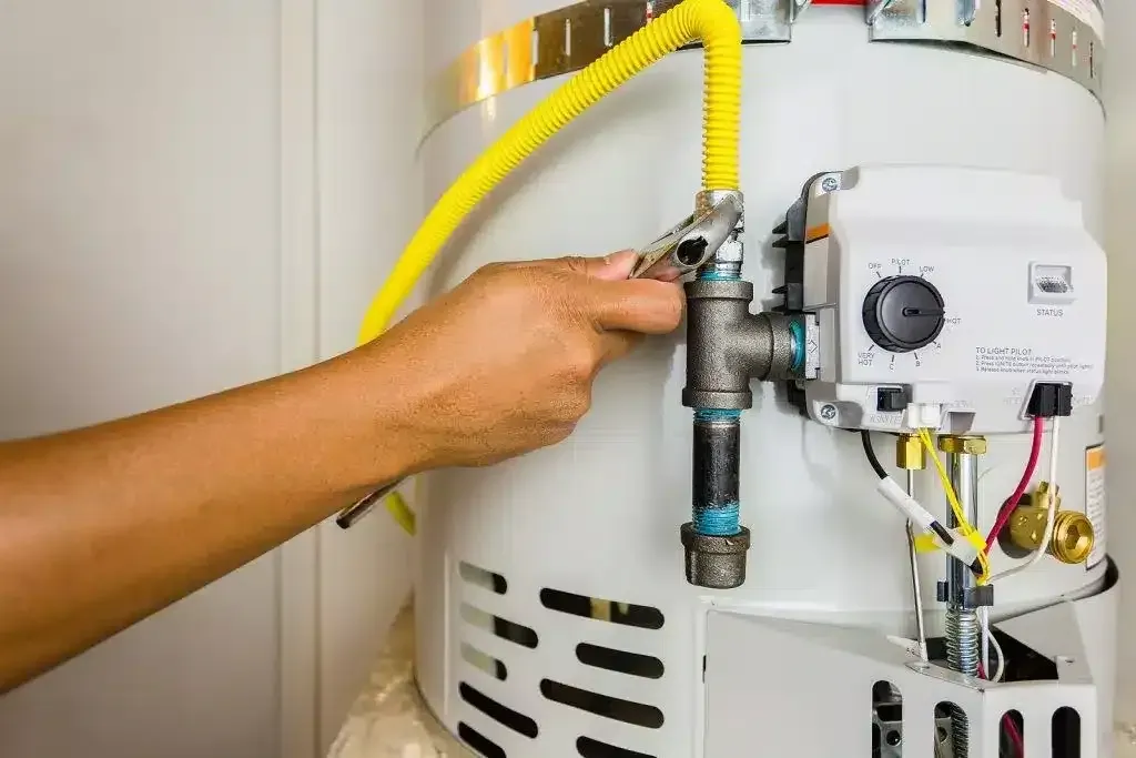 Hand adjusting the gas control valve on a gas storage hot water system