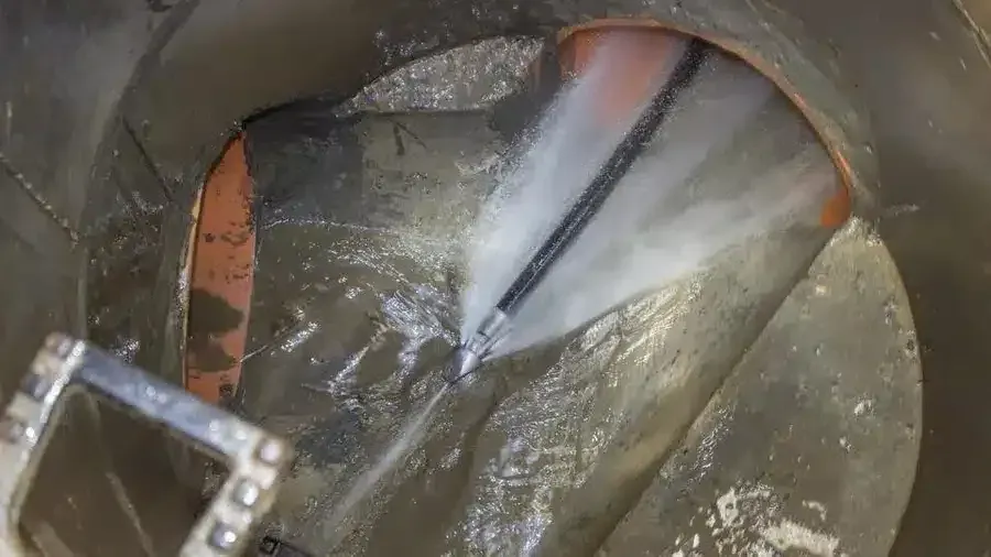 High-pressure hydro jet nozzle blasting the inside of a drain pipe