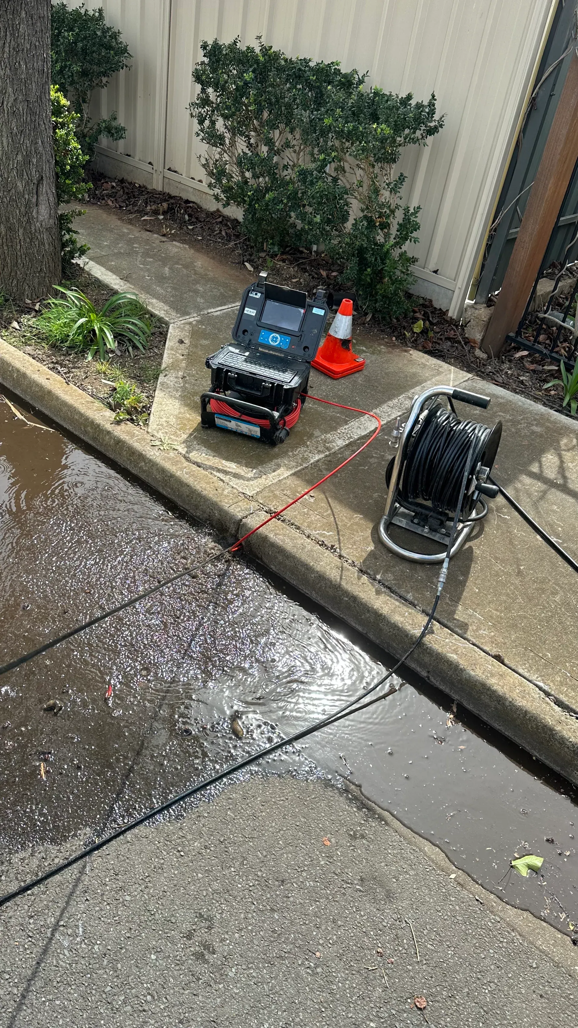 Hydro jet hose clearing a blocked drain from the kerb at an Adelaide home