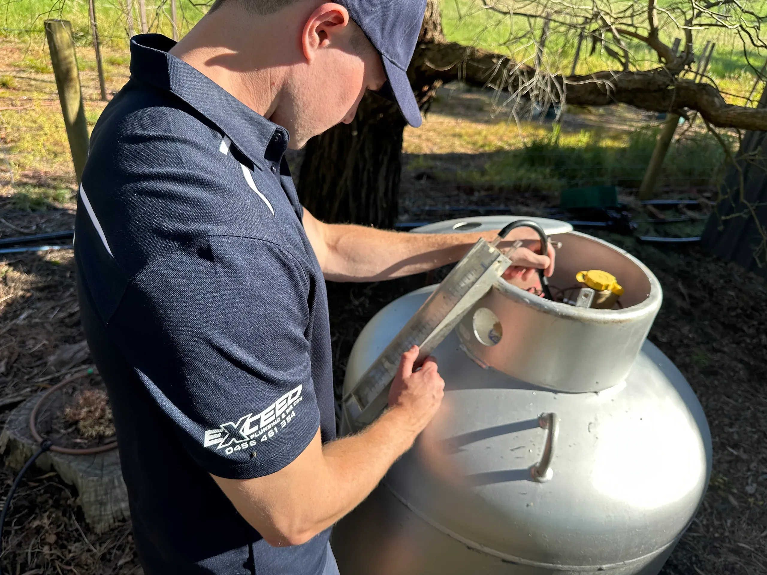 Exceed Plumbing gas fitter checking the valve on an LPG cylinder