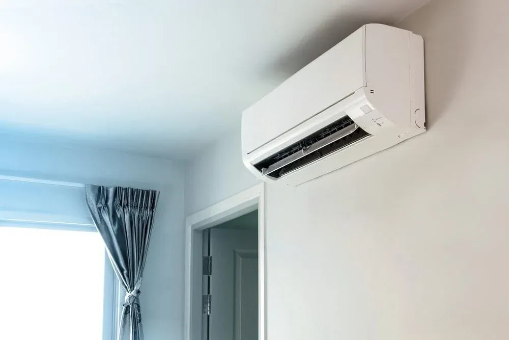 Split system air conditioner mounted high on a bedroom wall