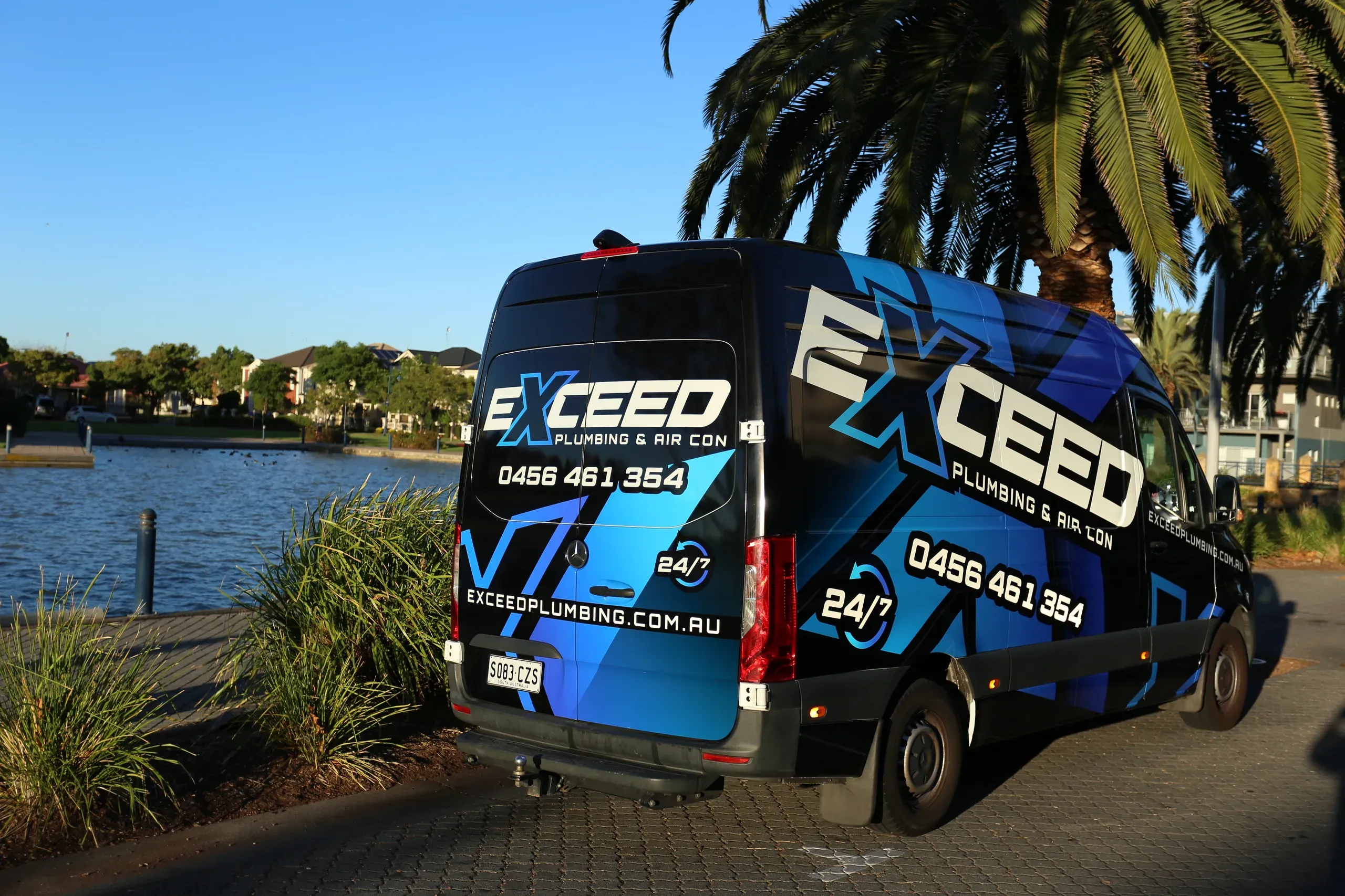 The Exceed Plumbing van parked beside the lake at Mawson Lakes