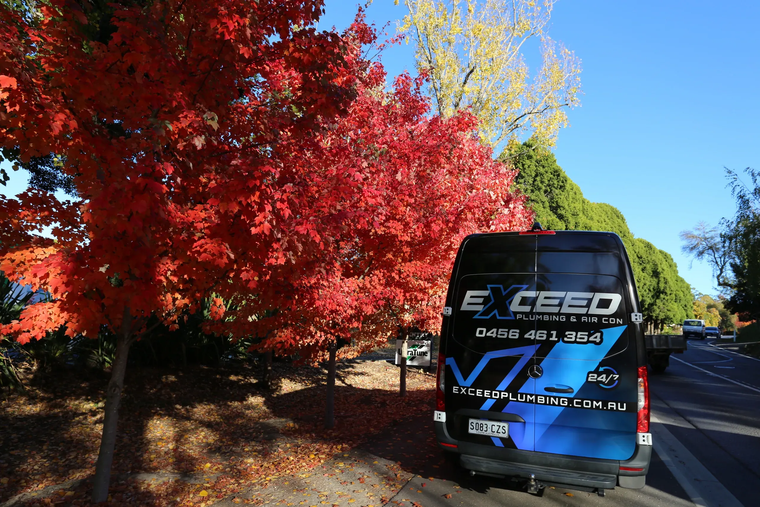 The Exceed Plumbing van under autumn trees in Stirling