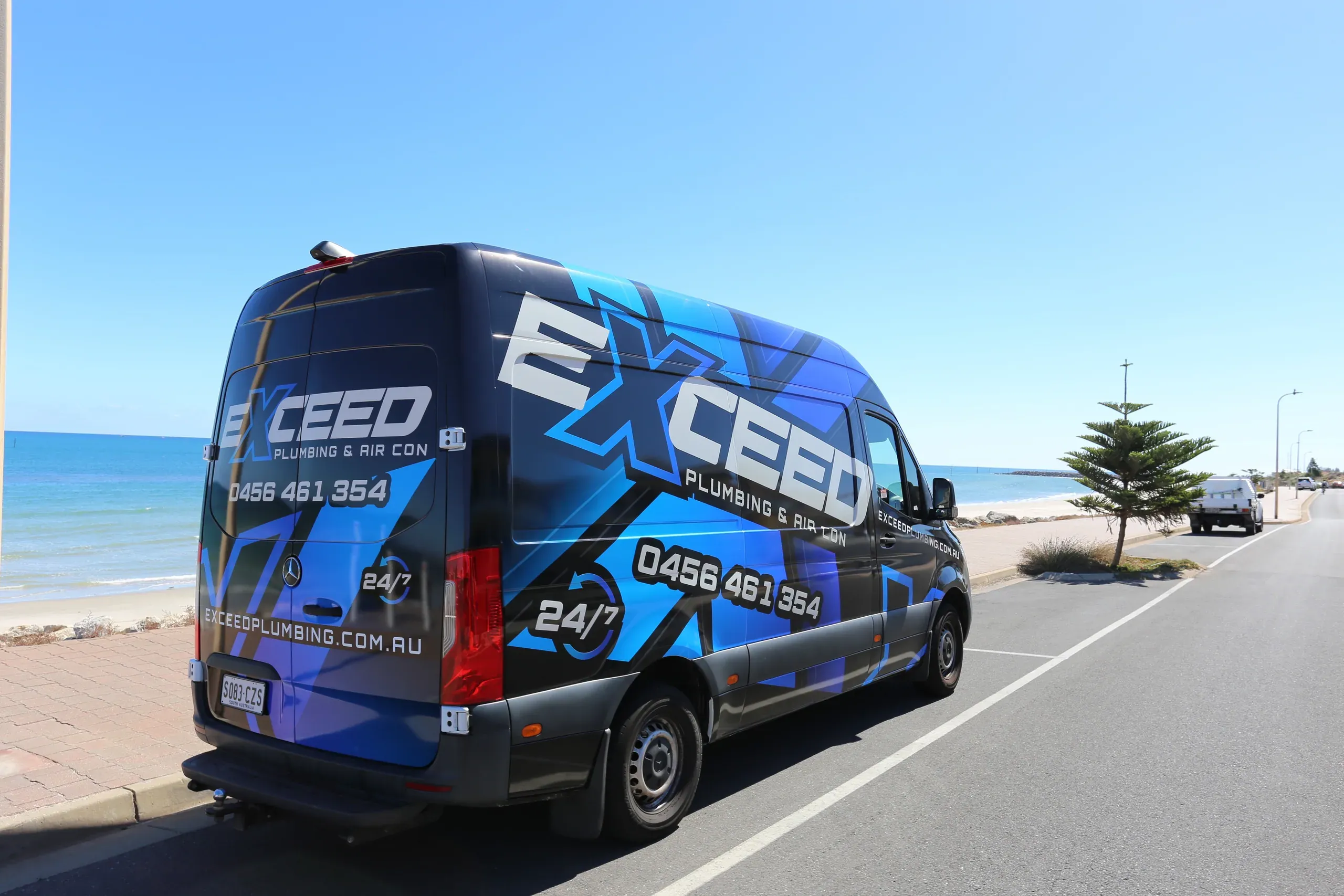 The Exceed Plumbing van parked by the beach at West Beach