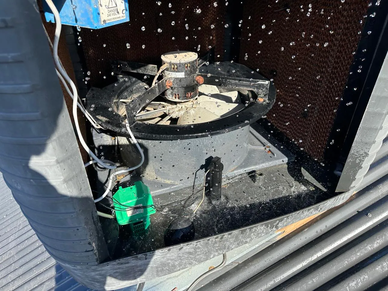 Inside an evaporative cooler, showing the motor and water pump