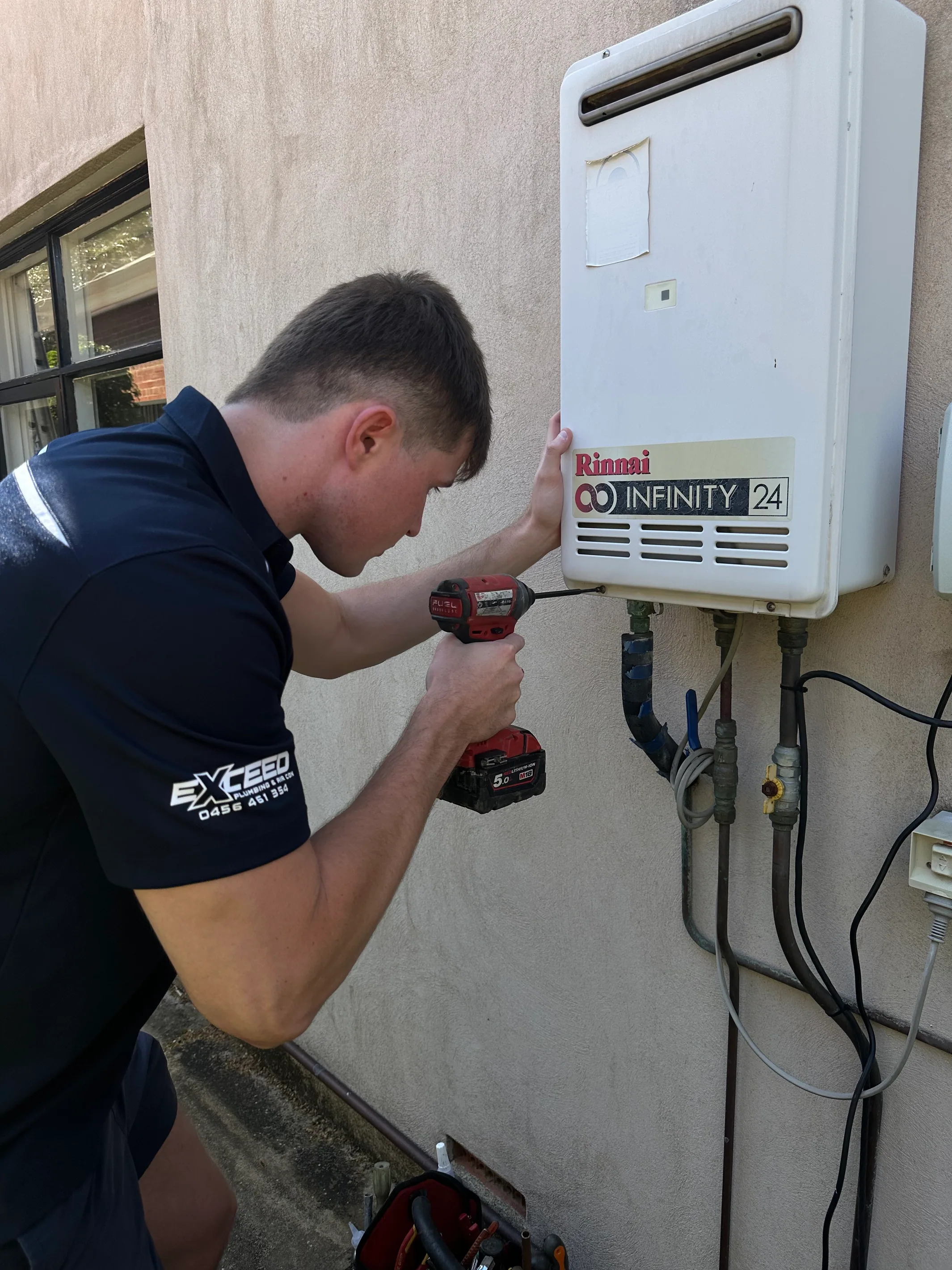Exceed Plumbing plumber fitting a Rinnai Infinity continuous flow hot water unit