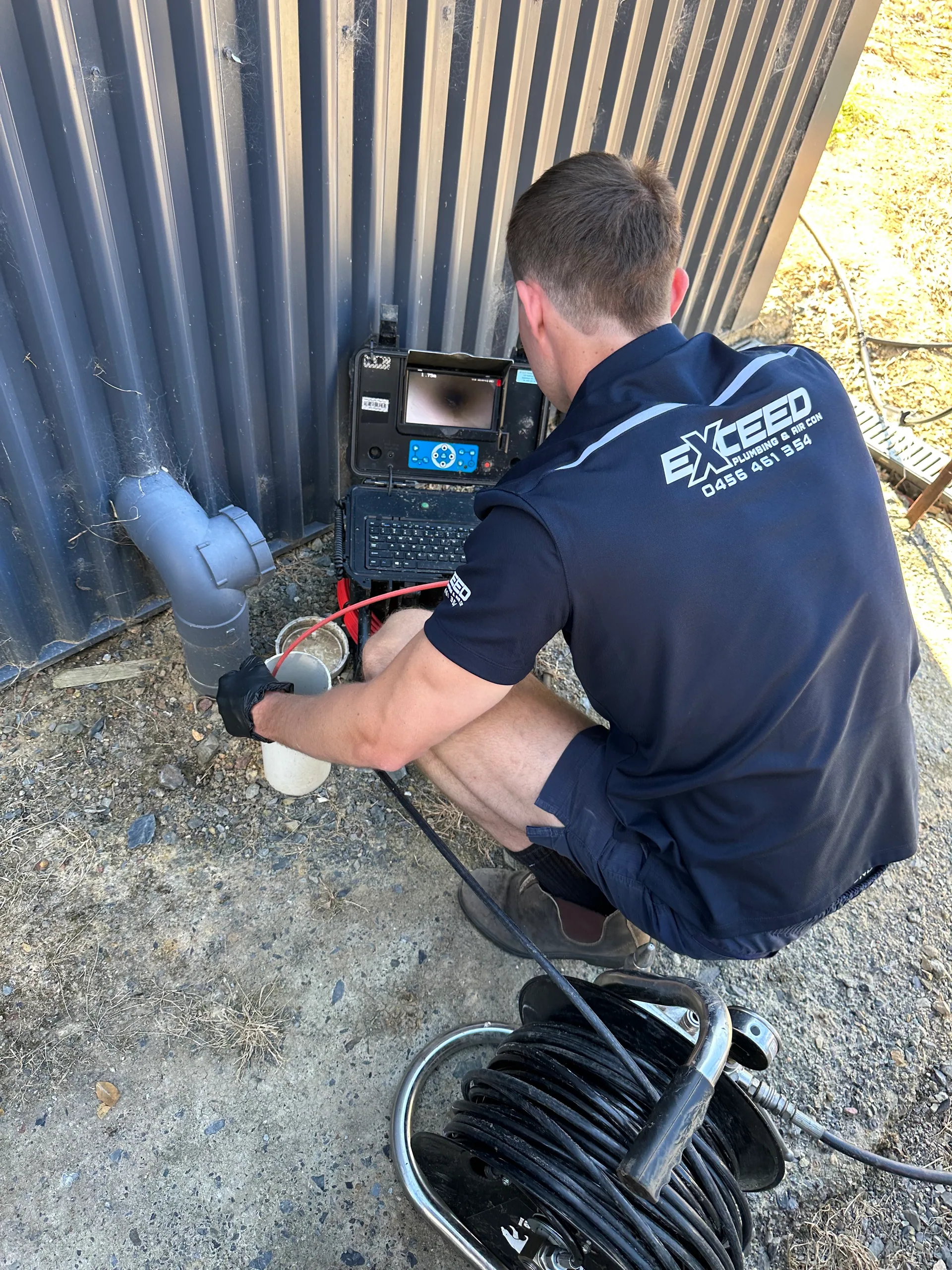 Exceed Plumbing plumber running a drain camera into a stormwater pipe