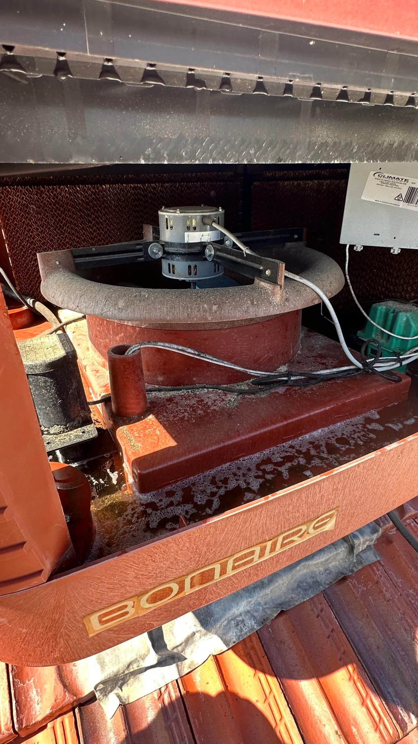 Bonaire evaporative cooler opened up on a tiled roof