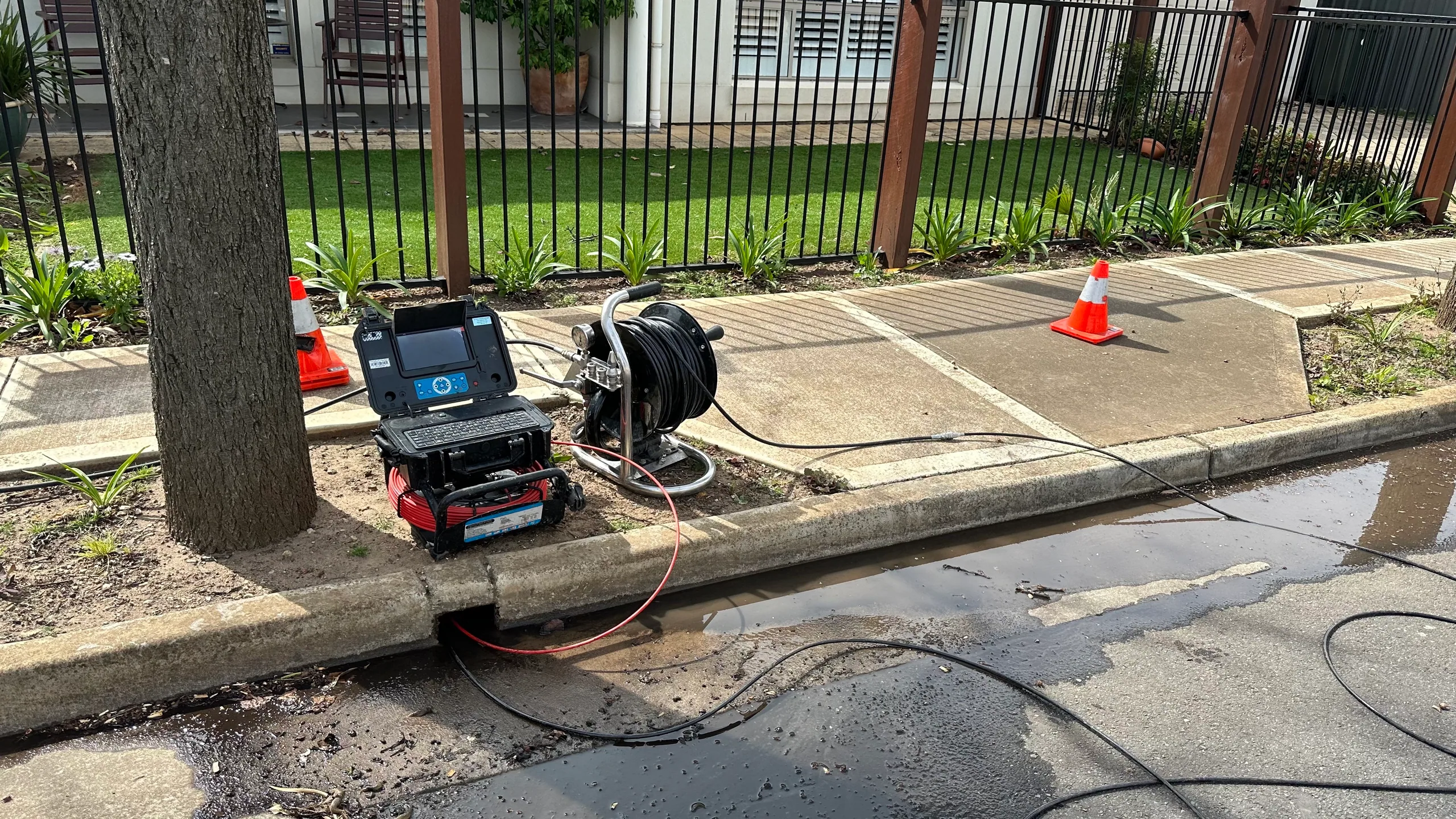 Drain camera and cable reel set up at the kerb with safety cones
